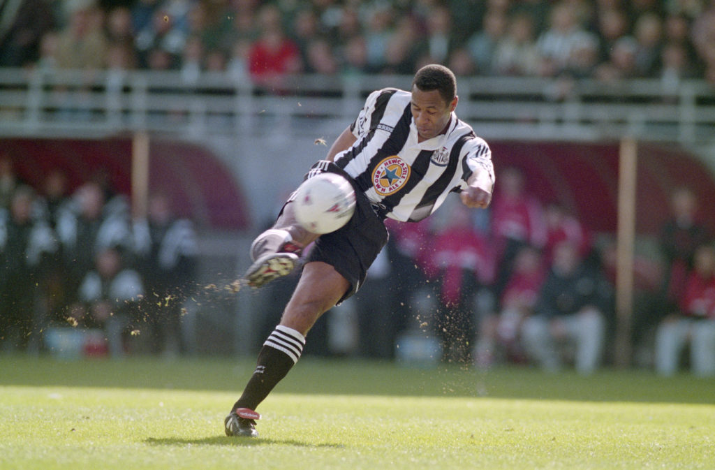 Les Ferdinand his a football for Newcastle United.