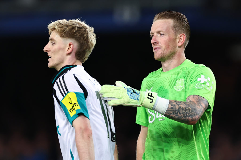 Jordan Pickford pats Anthony Gordon on the back.