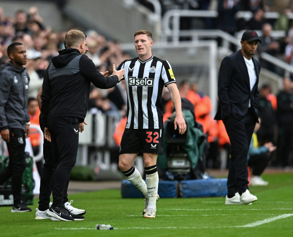 Eddie Howe and Elliot Anderson embrace during a Newcastle United game.