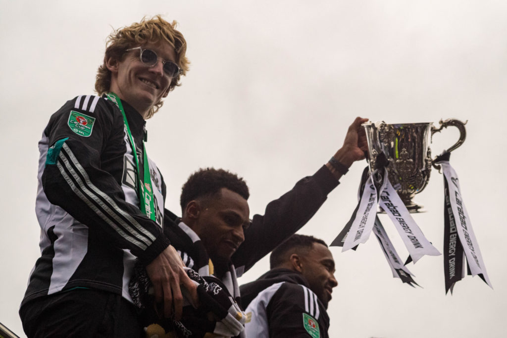 Newcastle United player, Jacob Murphy holds the League Cup