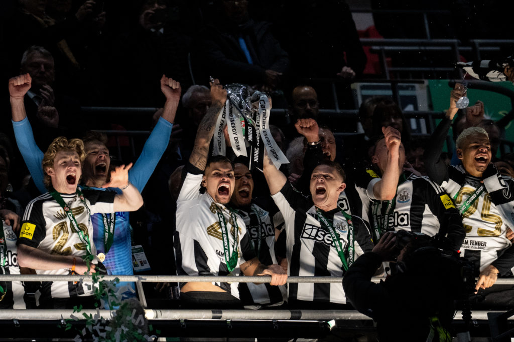 Bruno Guimaraes lifts the Carabao Cup trophy with Kieran Trippier and Jamaal Lascelles after Newcastle United beat Liverpool at Wembley.