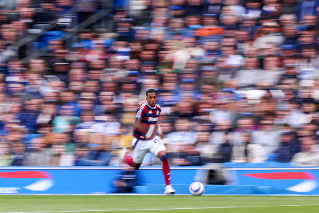 A blurred image of Joe Willock running on the ball for Newcastle United.
