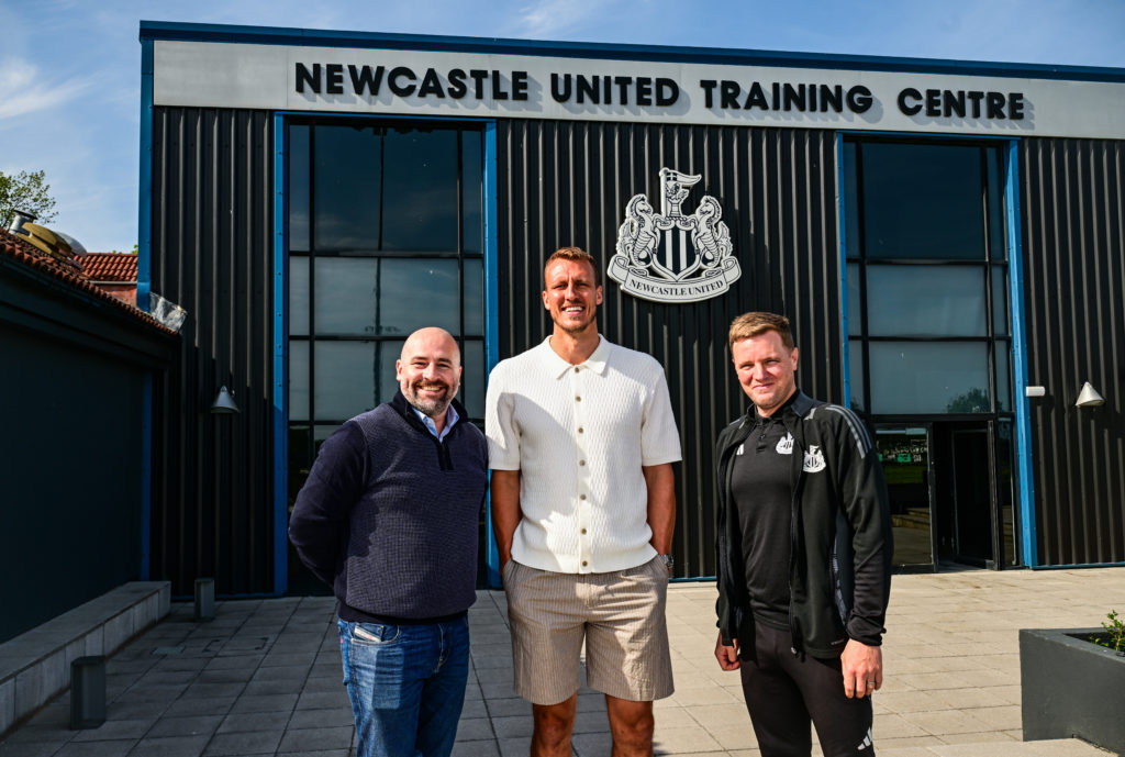 Paul Mitchell and Eddie Howe pose with Dan Burn after the defender signs a new contract with Newcastle United.