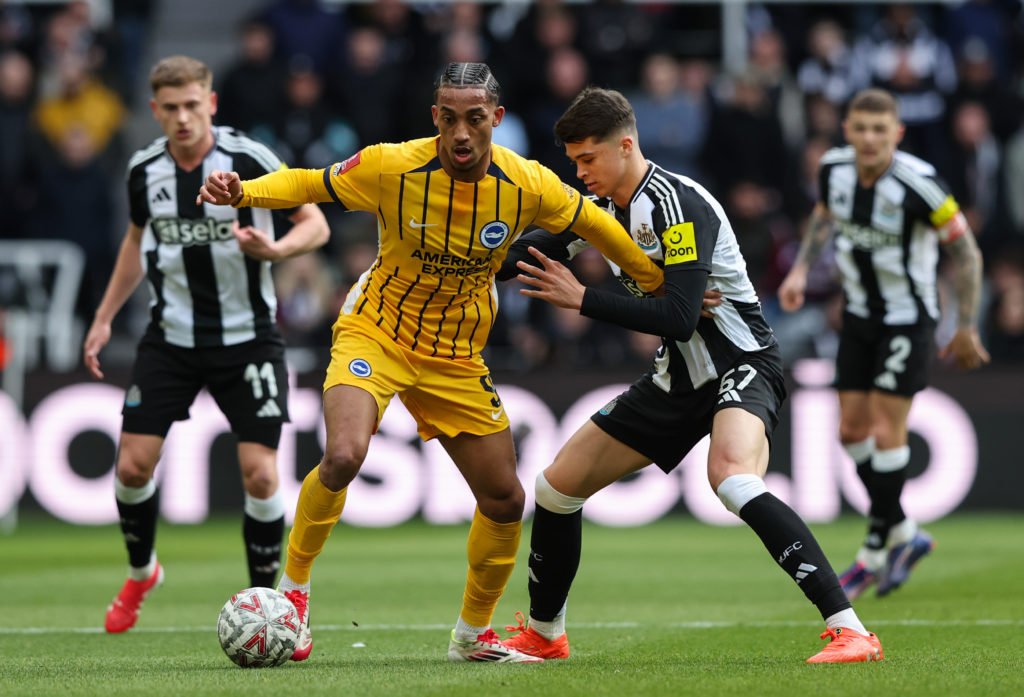 Brighton striker Joao Pedro holds on to possession despite pressure from Newcastle United's Lewis Miley.