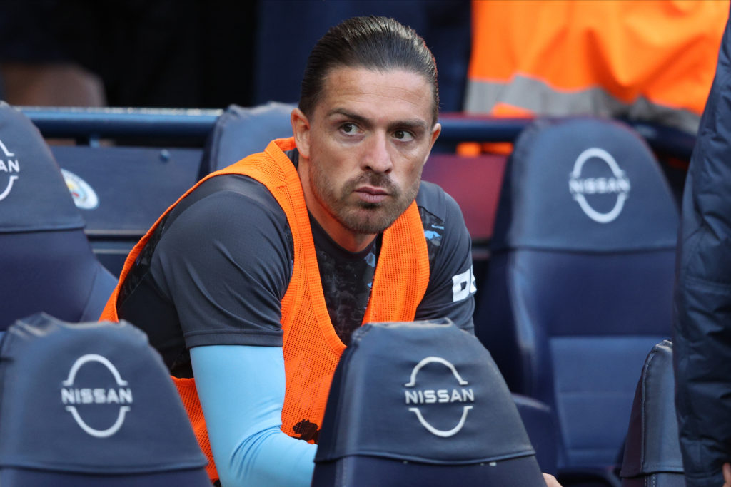 Jack Grealish watches on from the bench during a Premier League game between Manchester City and AFC Bournemouth.