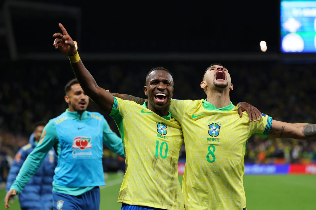 Bruno Guimaraes celebrates with Vinicius Junior after Brazil score against Paraguay in a World Cup qualifier.