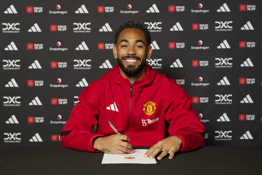Matheus Cunha poses with his Manchester United contract.