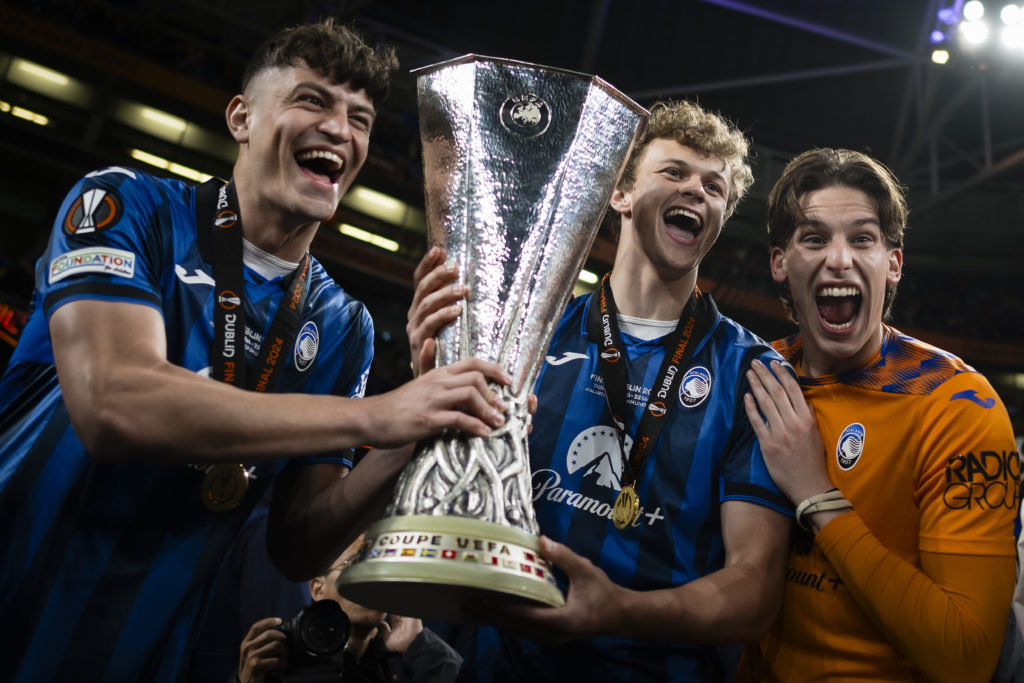 Giorgio Scalvini holds the Europa League trophy with his teammates after Atalanta's final win over Bayer Leverkusen.