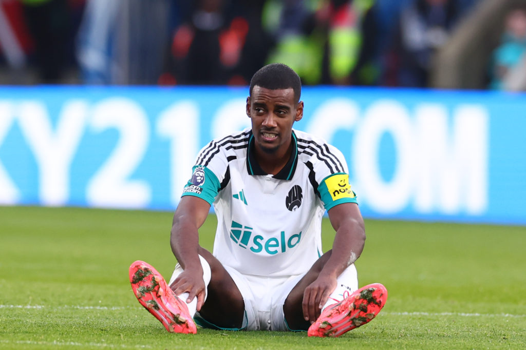 Alexander Isak sits on the ground after sustaining an injury during Crystal Palace vs Newcastle United.