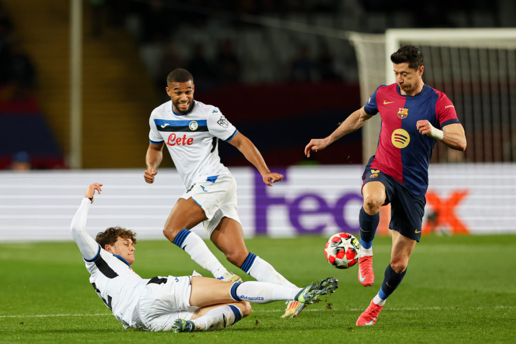 Georgio Scalvini slides in on Robert Lewandowski during a Champions League game between Atalanta and Barcelona.