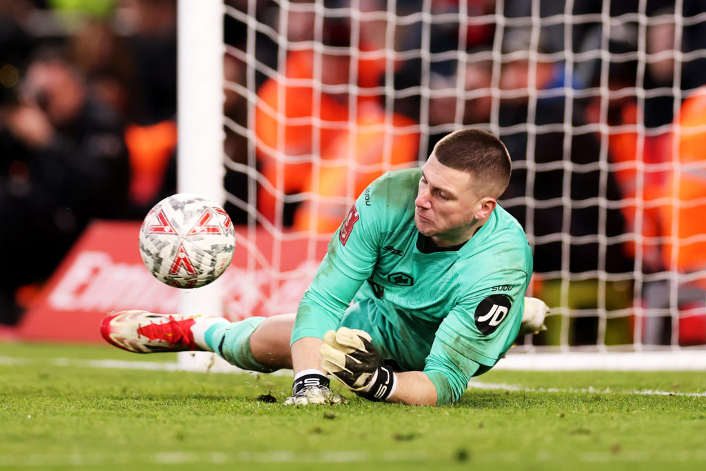 Sam Johnstone saves a penalty during an FA Cup tie between Bournemouth and Wolves.