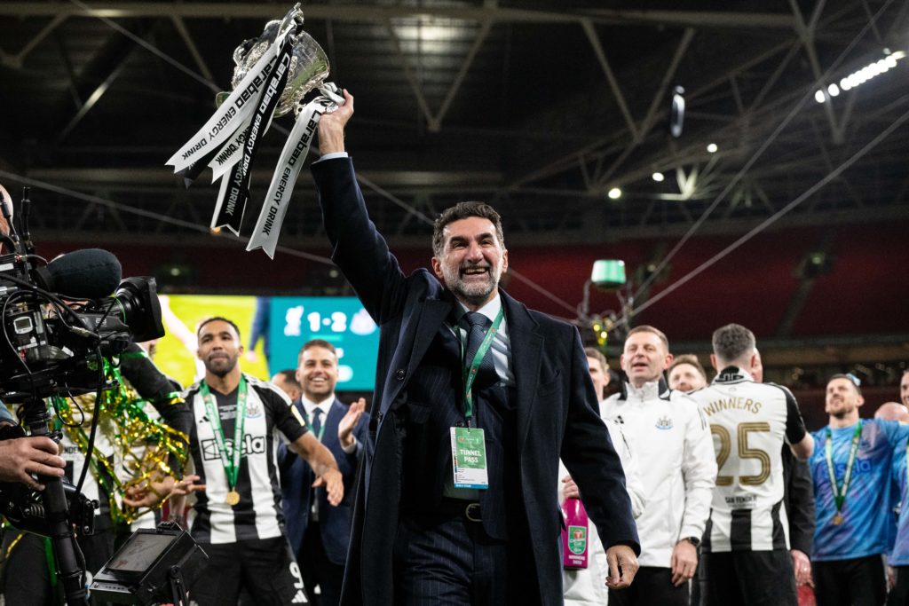 Newcastle United chairman Yasir Al-Rumayyan holds the Carabao Cup trophy in the air after beating Liverpool at Wembley.