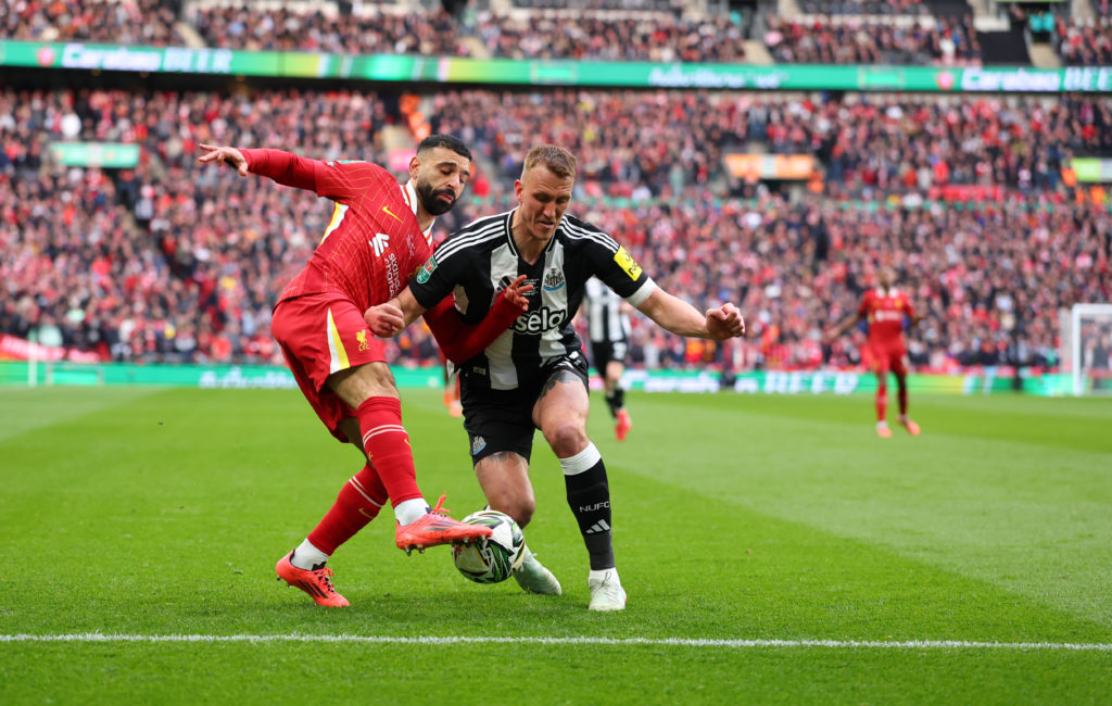 Mohamed Salah challenges Dan Burn during the Carabao Cup final between Newcastle United and Liverpool.