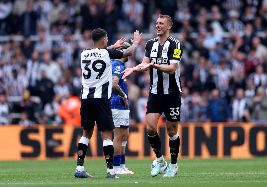 Dan Burn and Bruno Guimaraes embrace during a Premier League game between Newcastle United and Ipswich Town.