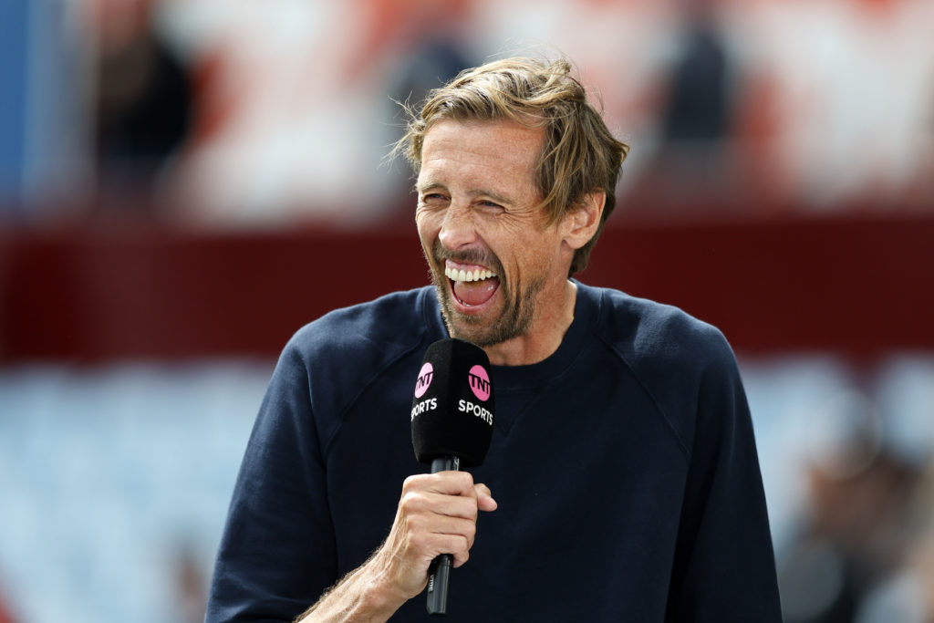 TNT Sports pundit Peter Crouch laughs while holding a microphone.
