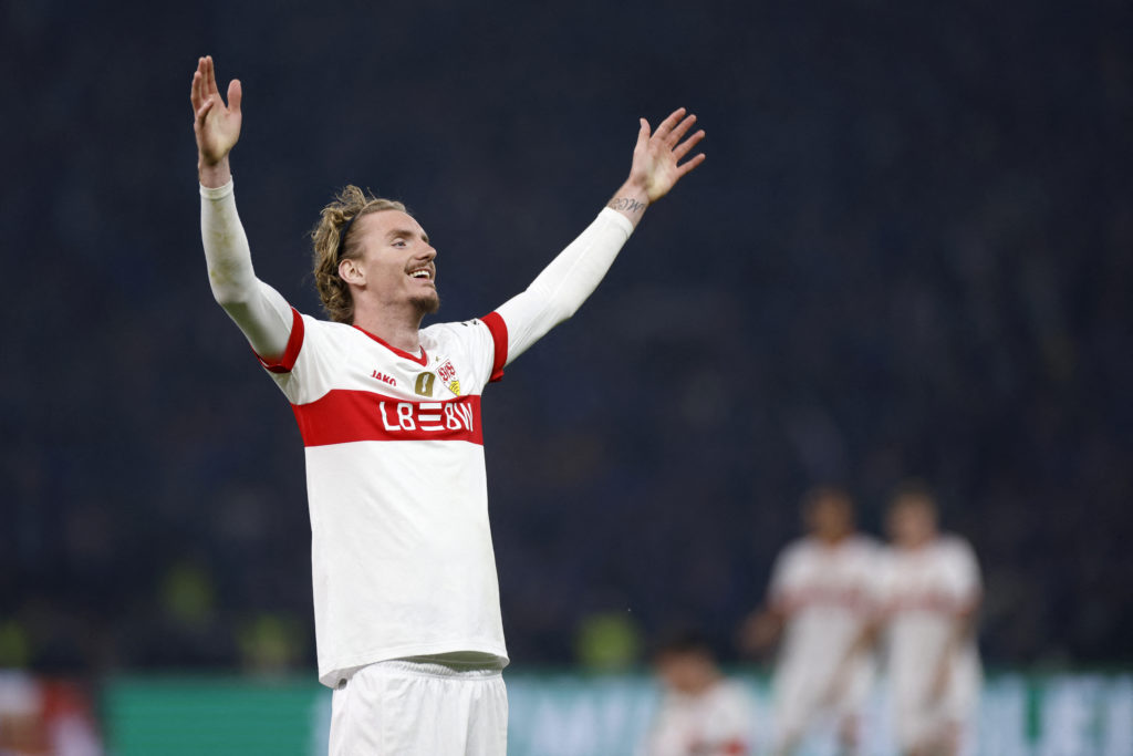 Nick Woltemade lifts his arms into the air in celebration.