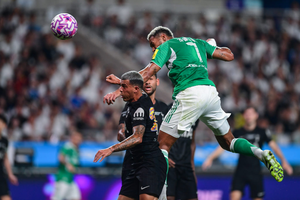 Joelinton jumps to win a header in Newcastle vs Tottenham.