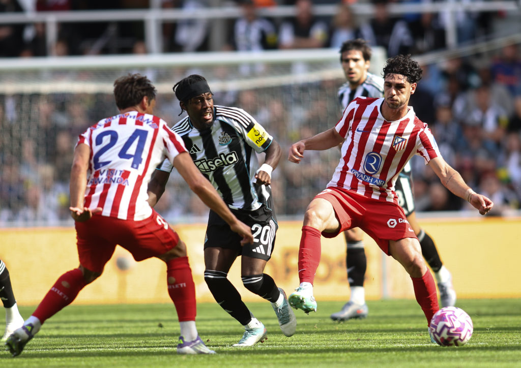 Anthony Elanga passes a ball under pressure during Newcastle United vs Atletico Madrid.