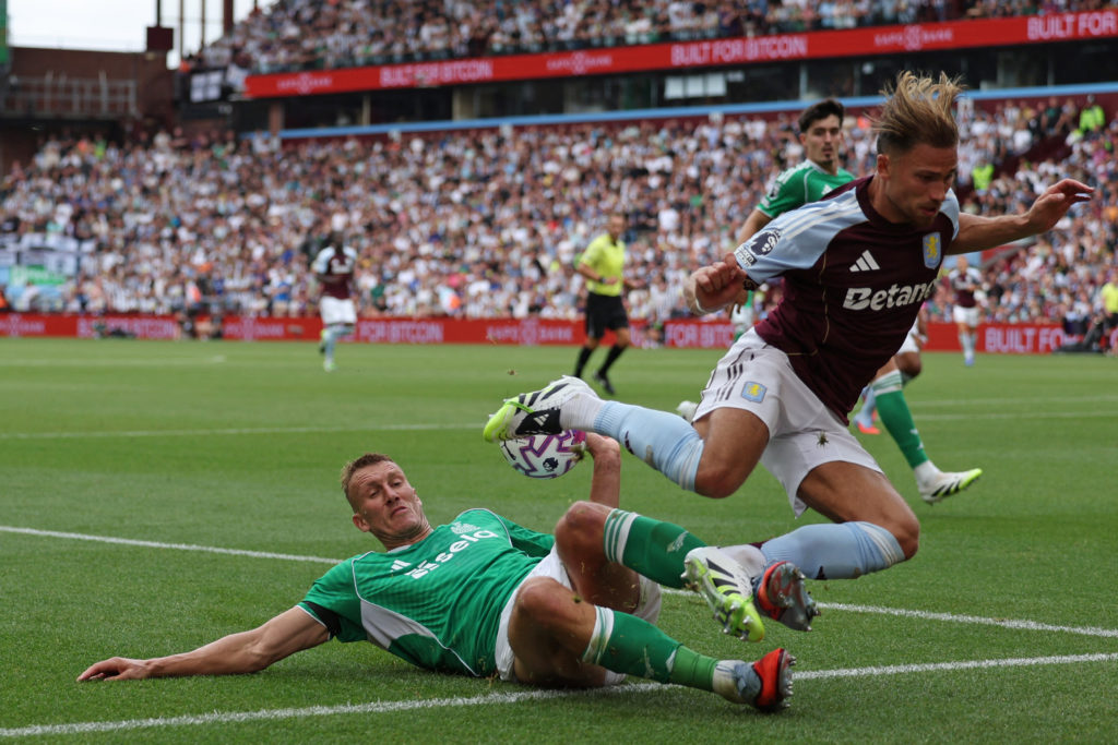 Dan Burn challenges Matty Cash during a Premier League game between Aston Villa and Newcastle United.