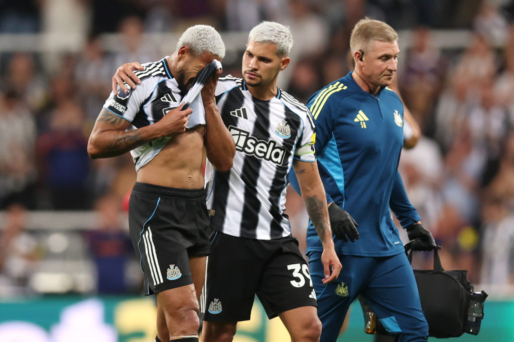 Joelinton is consoled by Bruno Guimaraes during a Premier League game between Newcastle United and Liverpool.