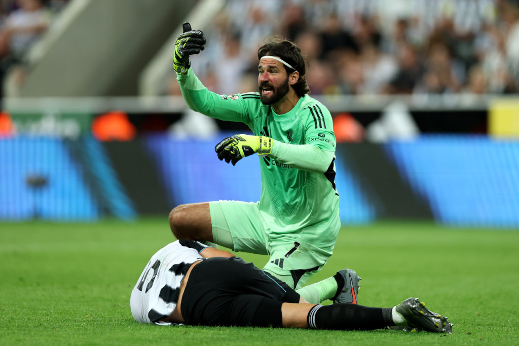 Alisson Becker ushers physios over to help Fabian Schar during a Premier League game between Newcastle United and Liverpool.