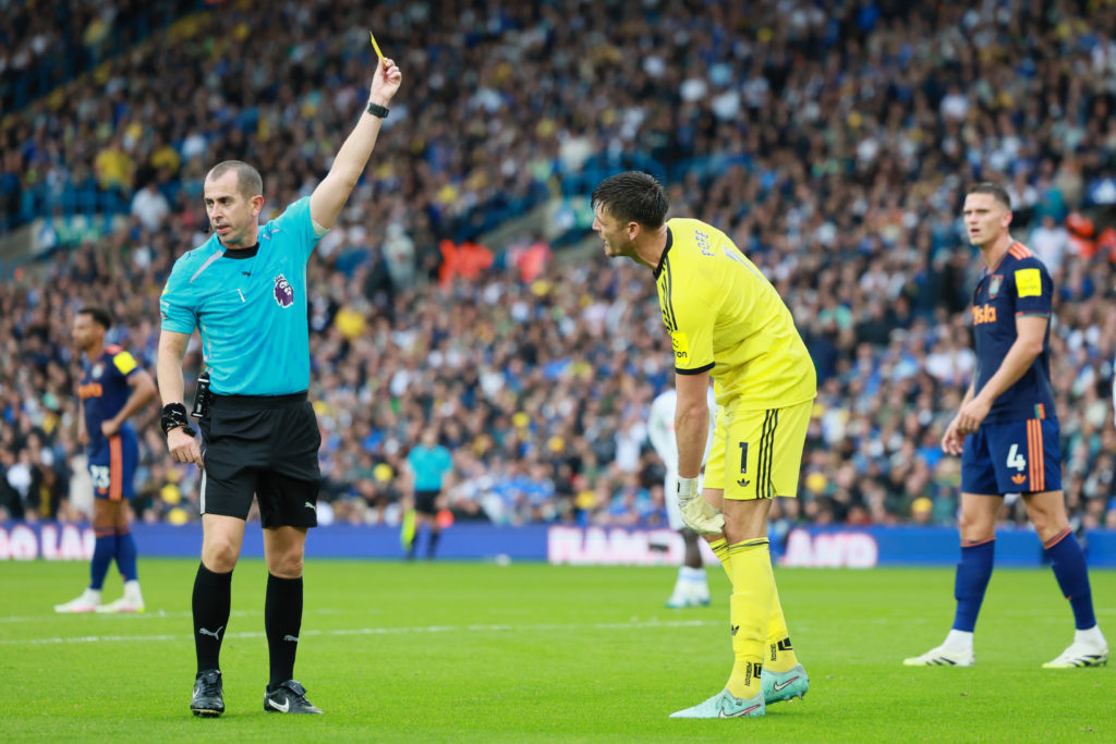 Newcastle United goalkeeper Nick Pope is shown a yellow card while playing against Leeds United in the Premier League.