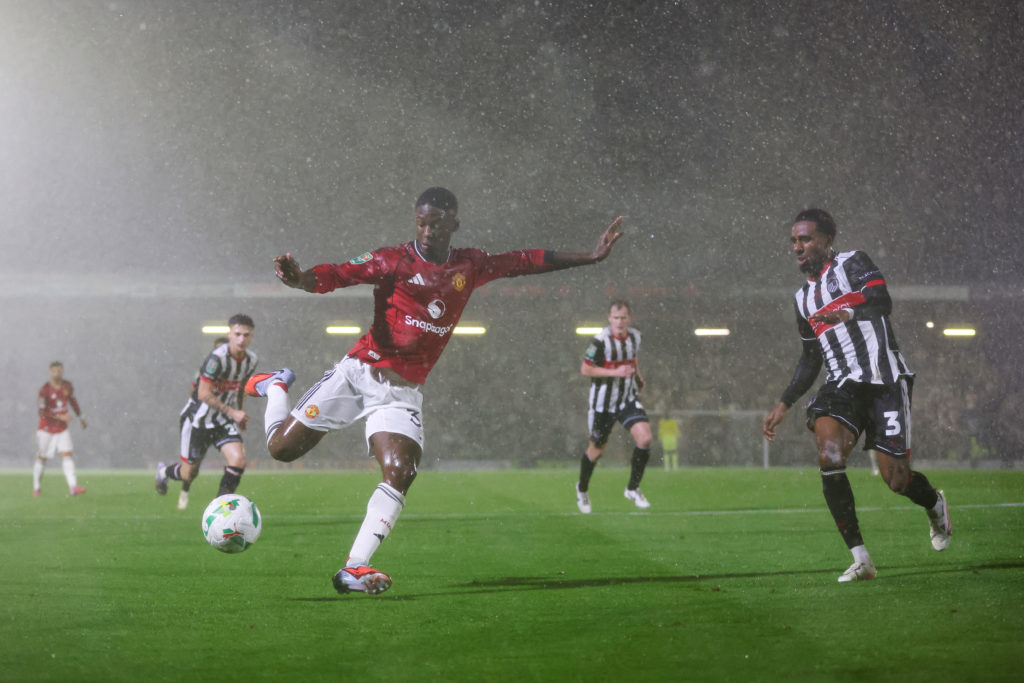 Kobbie Mainoo strikes the ball during a Carabao Cup game between Grimsby Town and Manchester United.