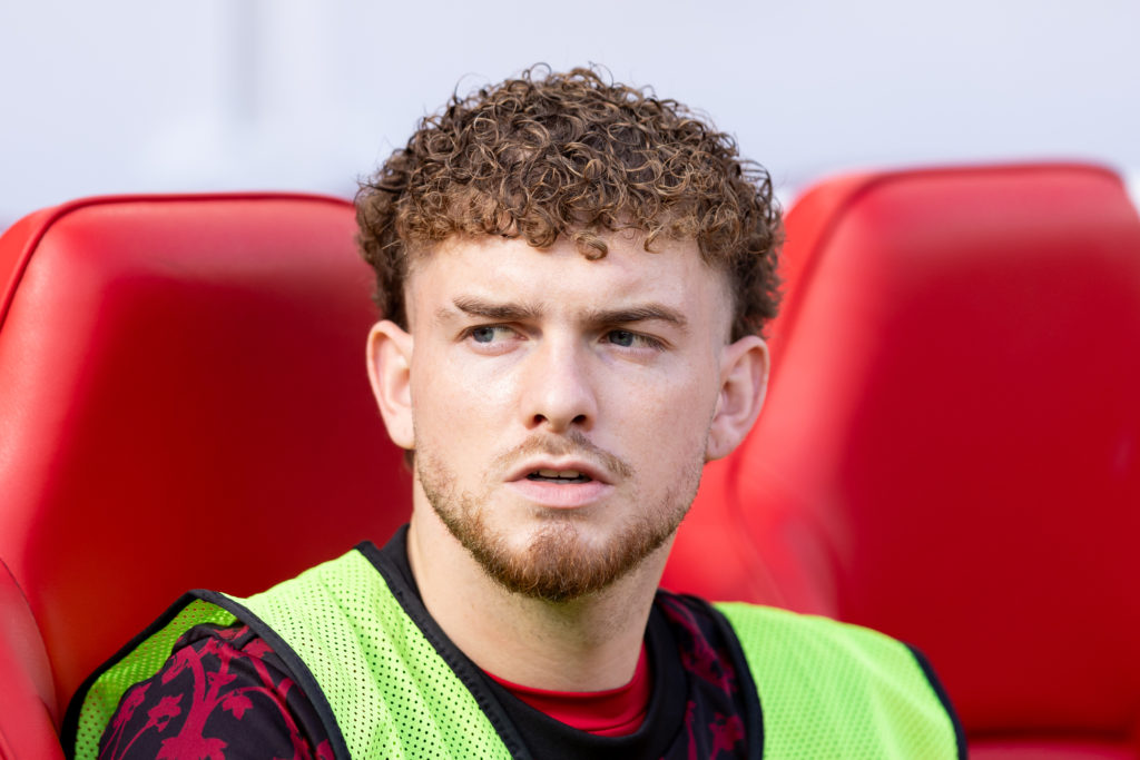 Harvey Elliott sitting on the Liverpool bench.