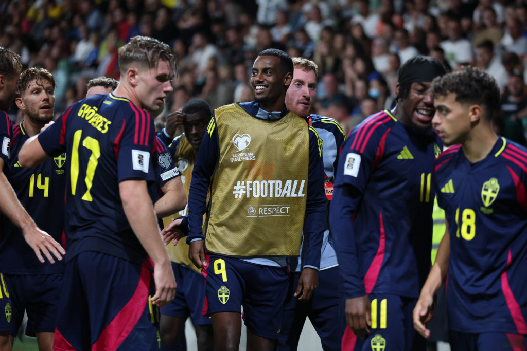 Alexander Isak celebrates with his teammates from the bench as Sweden score against Slovenia.