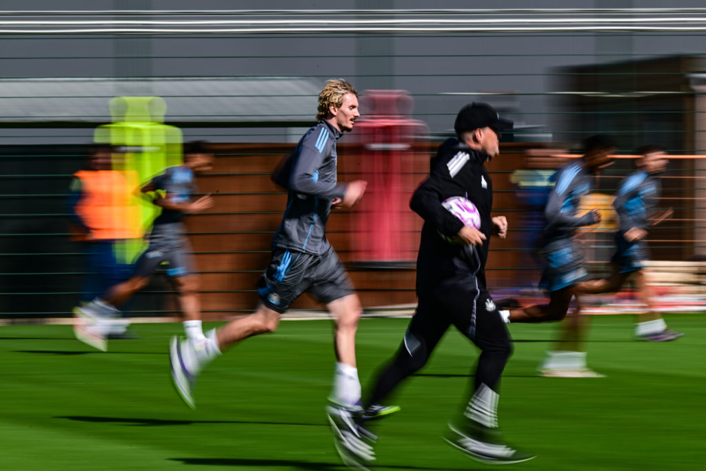 Nick Woltemade runs next to Eddie Howe during Newcastle United training.