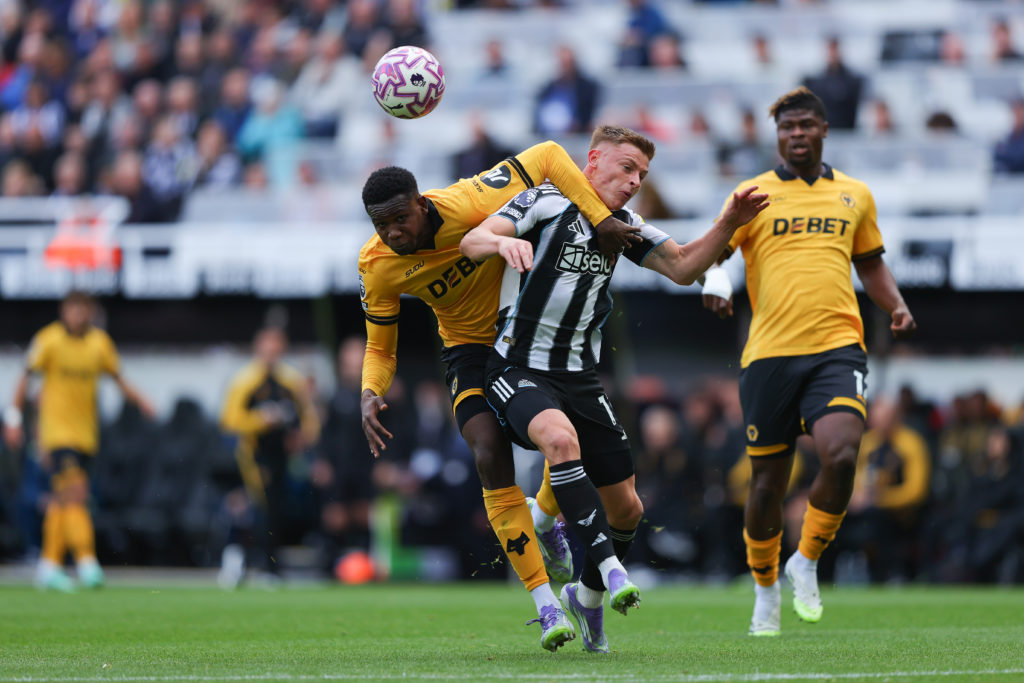 Harvey Barnes tussles with Yerson Mosquera during a Premier League game between Newcastle United and Wolves.