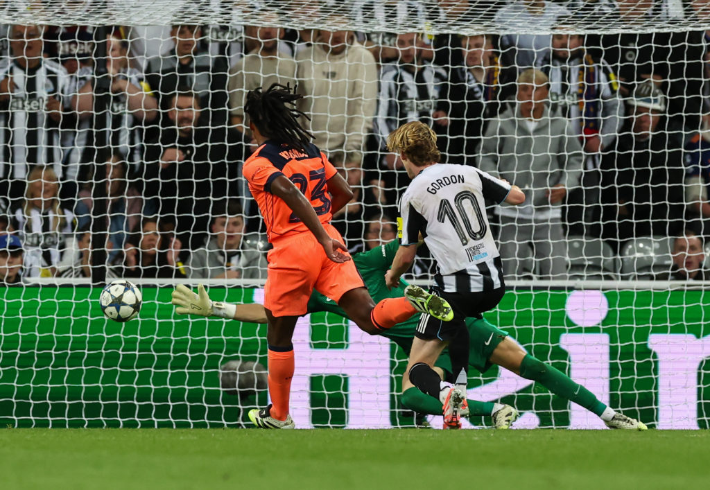 Anthony Gordon scores a goal during a Champions League game between Newcastle United and Barcelona.