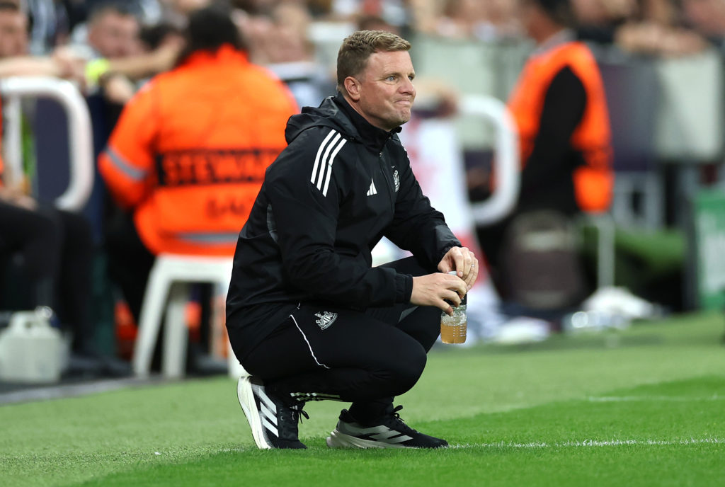 Eddie Howe crouched on the touchline during a Champions League game between Newcastle United and Barcelona.