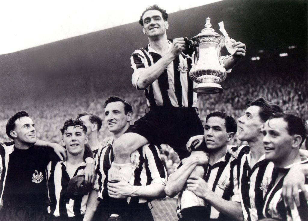 Joe Harvey holds the FA Cup in the air as Newcastle United captain.
