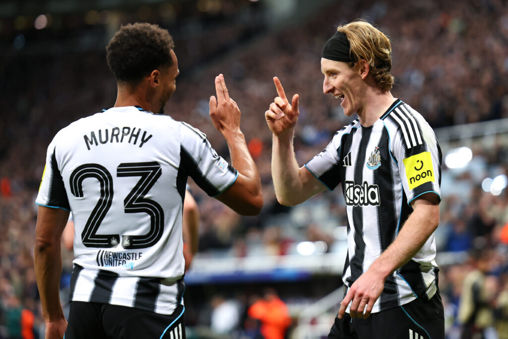 Anthony Gordon celebrates with Jacob Murphy after scoring Newcastle United's first goal against Benfica in the Champions League.