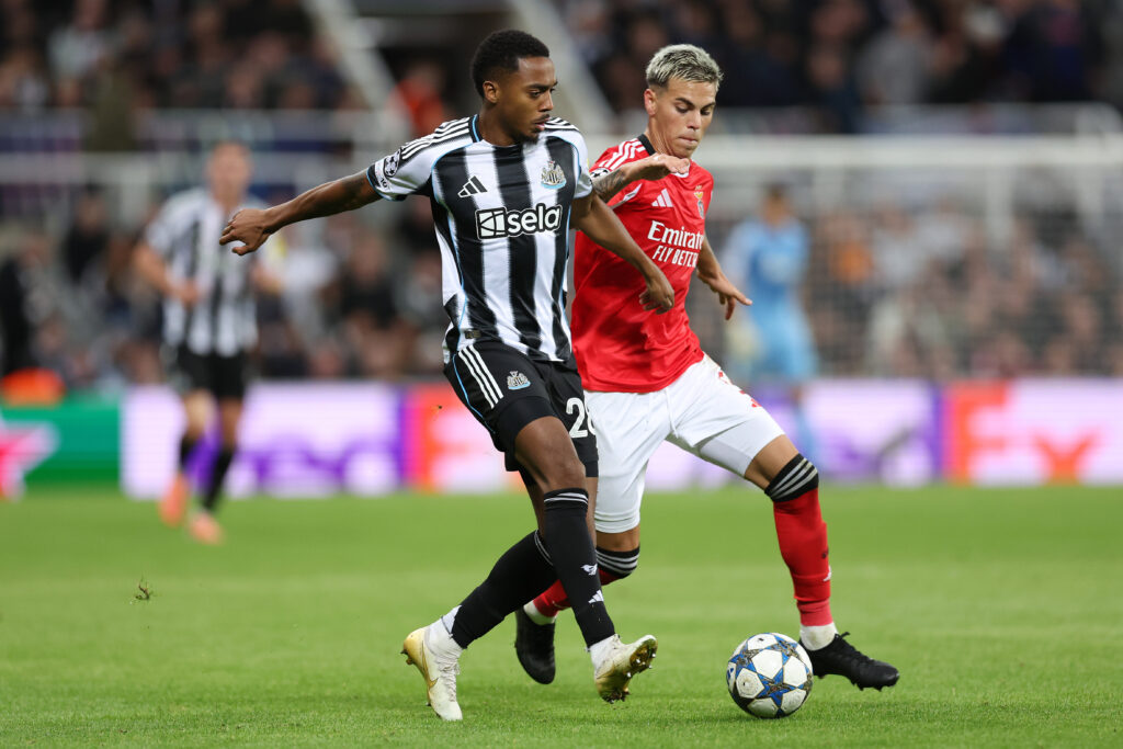Joe Willock is challenged for the ball during Newcastle United's Champions League game against Benfica.