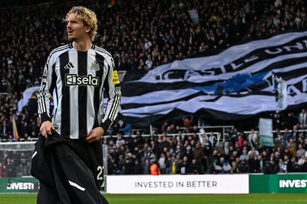 Nick Woltemade gets ready to play for Newcastle United against Fulham with a PIF advert in the background.