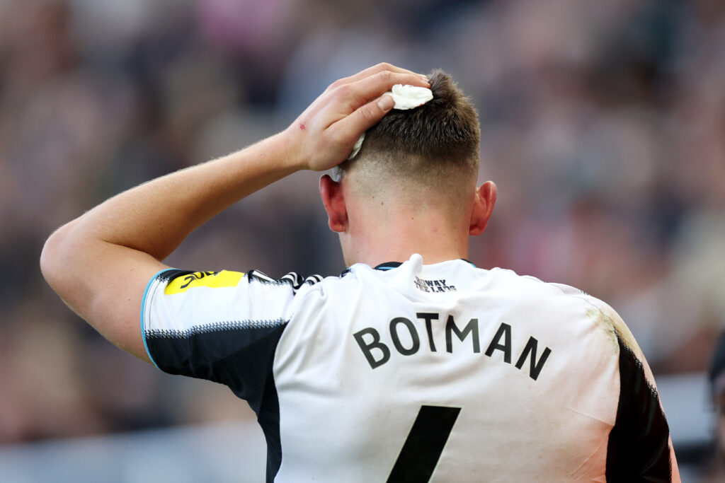 Sven Botman holding a bandage on his head after being substituted for Newcastle United vs Fulham.