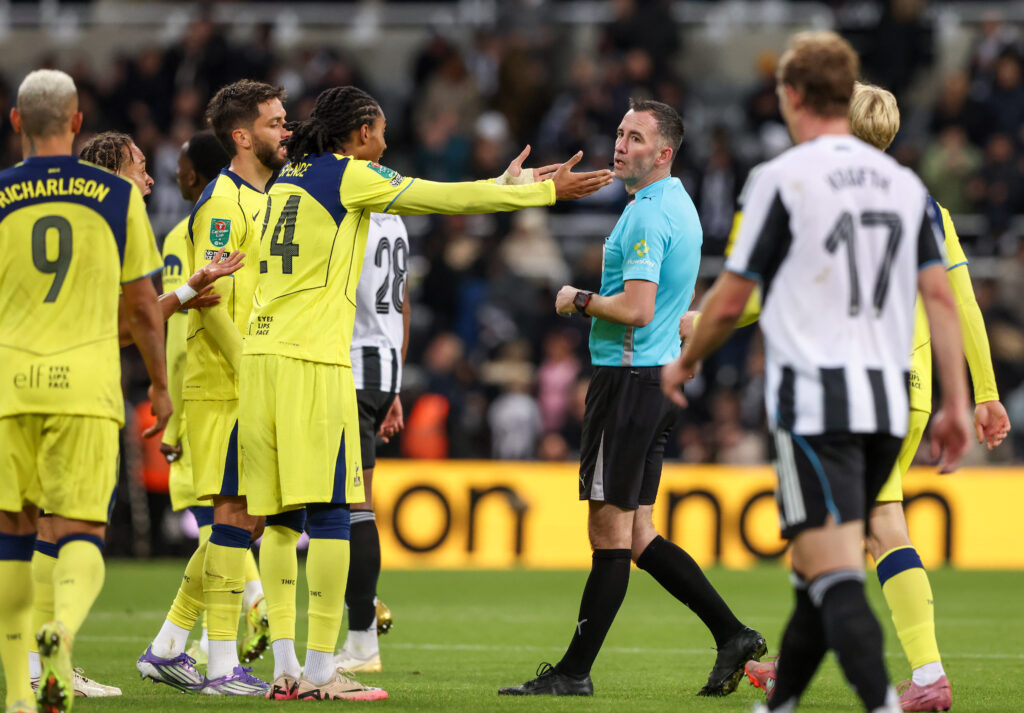 Djed Spence and Tottenham players complain to a referee.