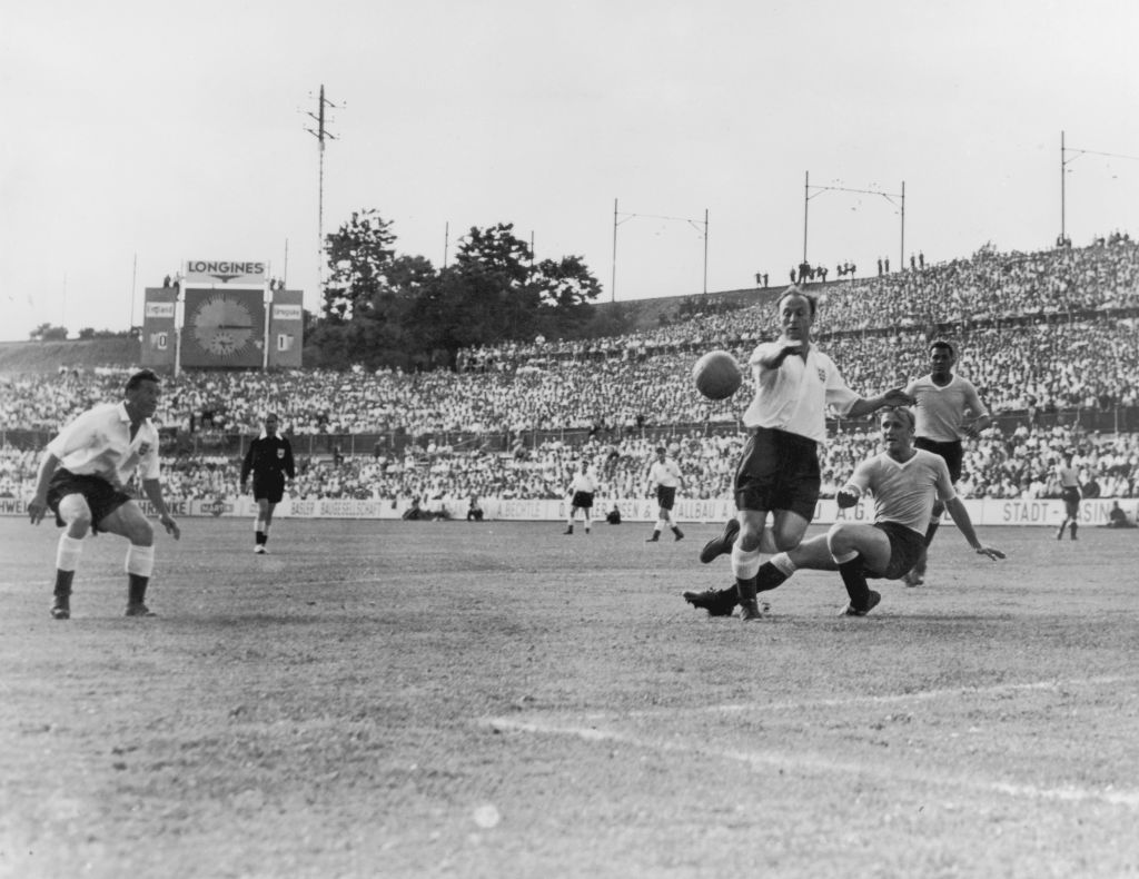 Ivor Broadis of England jumps over the outstretched leg of William Martinez of Uraguay in front of the Uraguayan goal during a World Cup quarterfinal match at the St. Jakob Stadium, Basel, Switzerland, 26th June 1954.