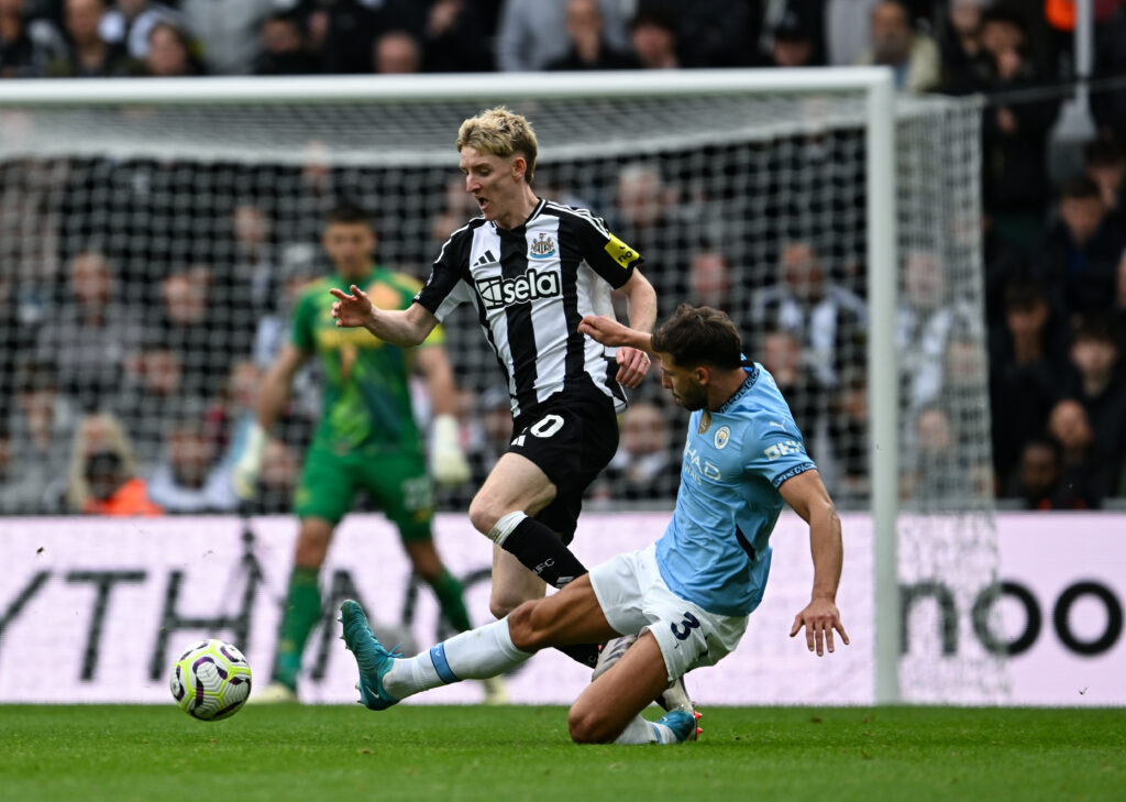 Anthony Gordon is challenged by Ruben Dias during Newcastle United vs Manchester City.