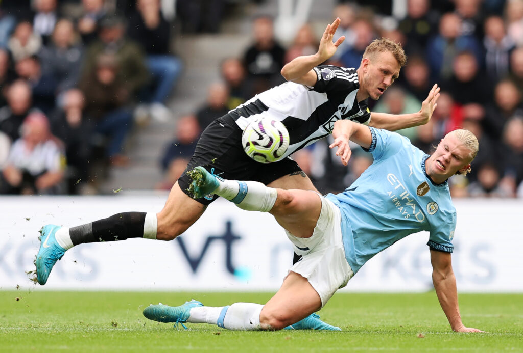 Dan Burn challenges Erling Haaland during Newcastle United vs Manchester City.