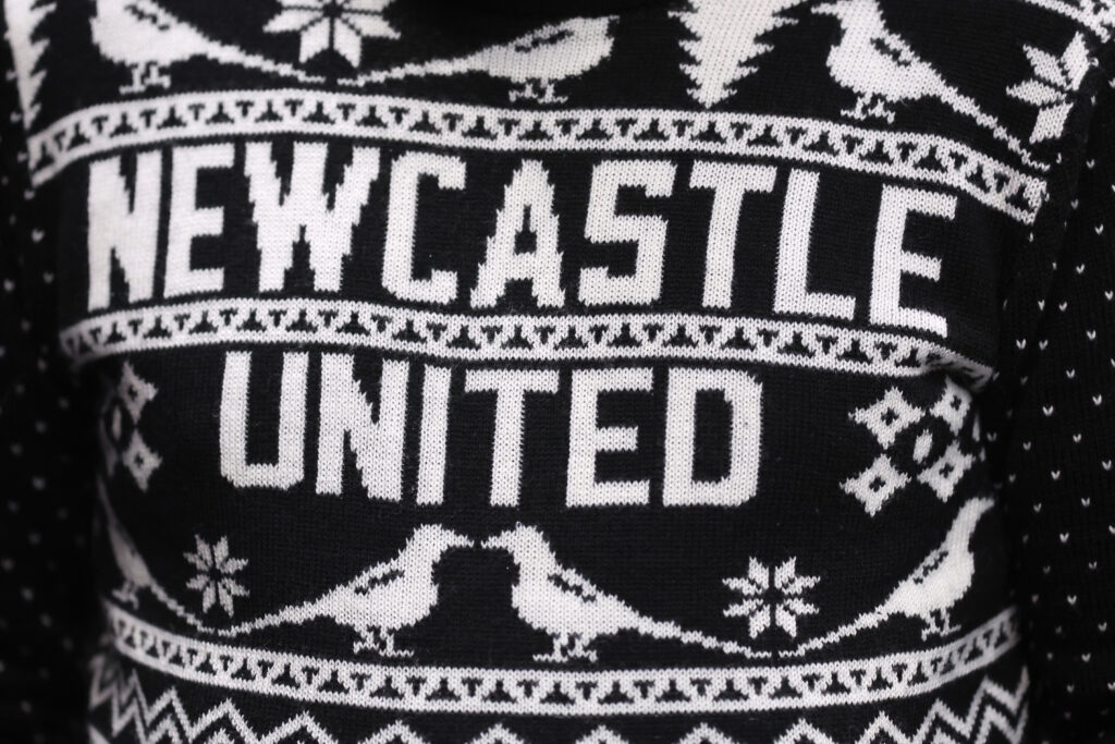 A close-up shot of a Newcastle United fan wearing a Christmas jumper.