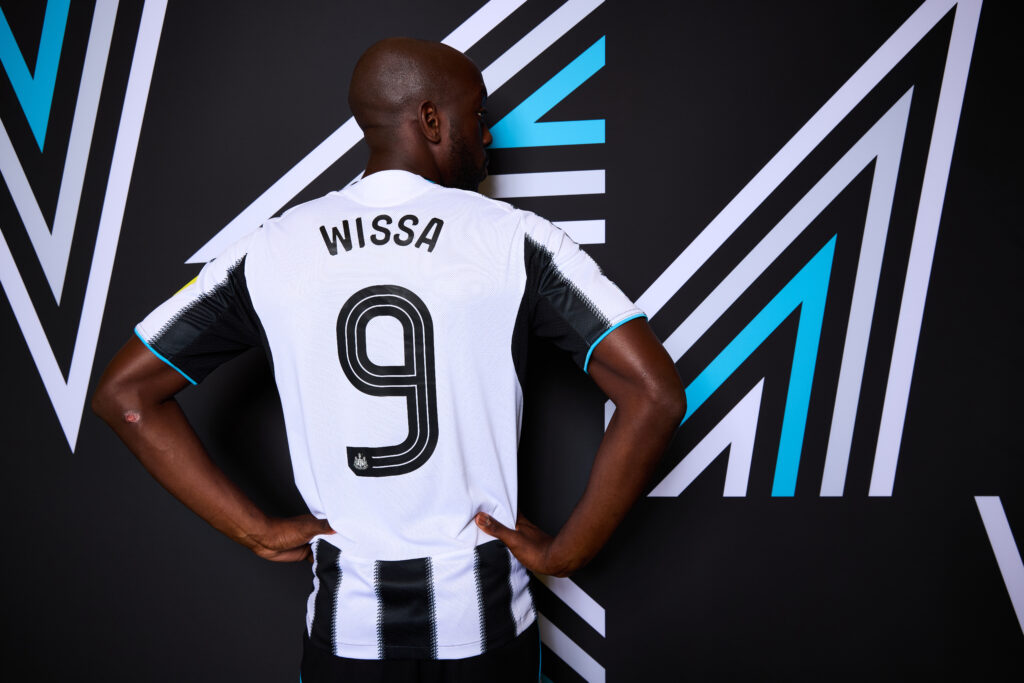 Yoane Wissa poses in a Newcastle United shirt.