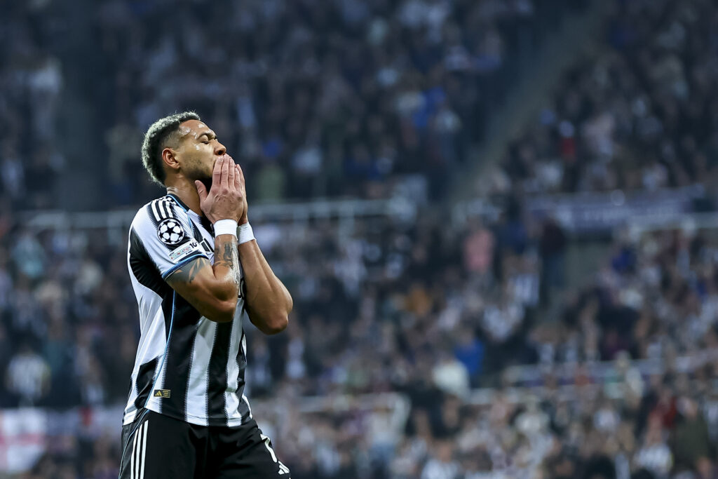 Joelinton holds his face and closes his eyes in anguish.