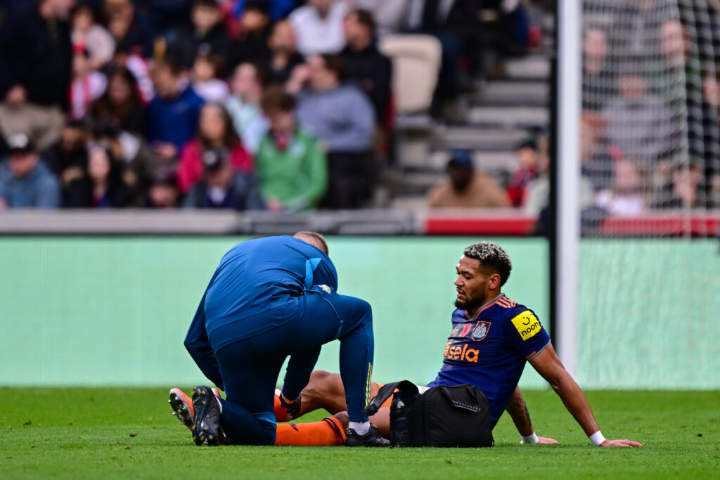 Joelinton recieves treatment on an injury during Newcastle United's Premier League match against Brentford.