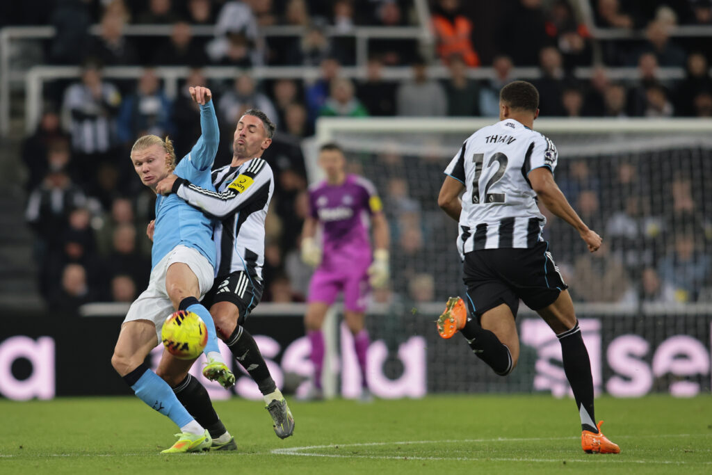 Fabian Schar challenges Erling Haaland during Newcastle United's Premier League game against Manchester City.
