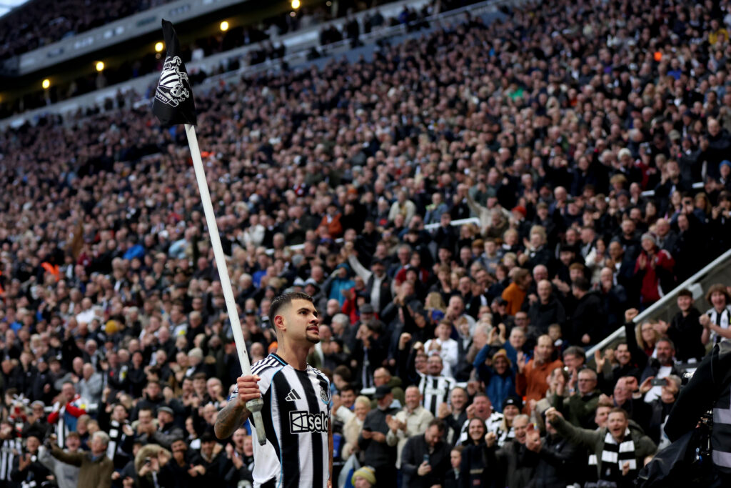 Bruno Guimaraes celebrates scoring for Newcastle United against Burnley by holding up the corner flag.