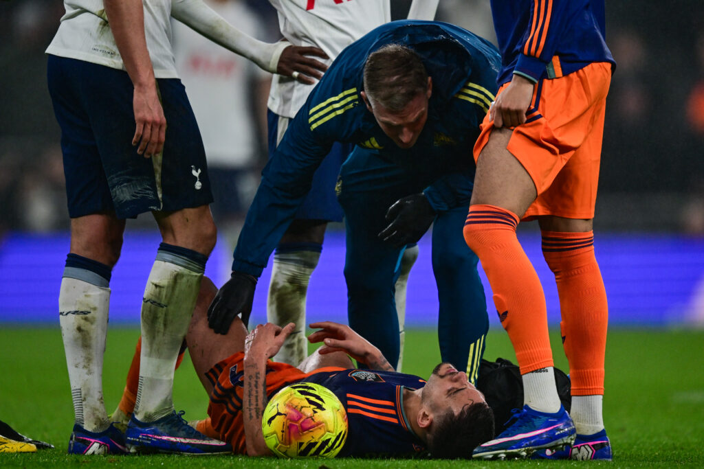 Bruno Guimaraes goes down injured with a hamstring problem during Newcastle United's match with Tottenham in the Premier League.